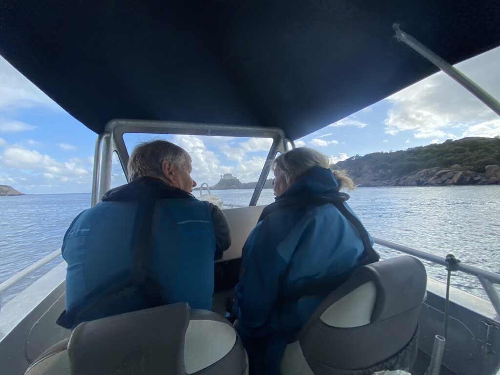 Two people in a boat, looking forward over the water