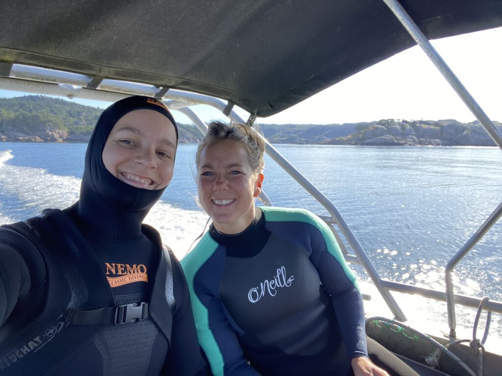 Two women in wetsuits, ready for the water