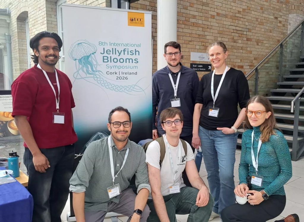6 jellyfish researchers posing in front of a rollup with the conference logo